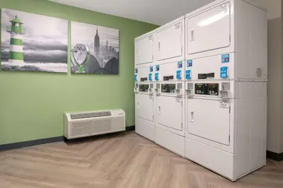 a room with white appliances and a green wall at Extended Stay America Suites - Orange County - John Wayne Airport in Newport Beach
