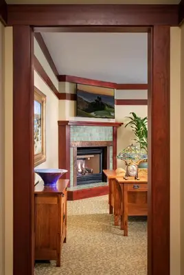 a living room with a fireplace and a table at The Lodge at Torrey Pines in San Diego