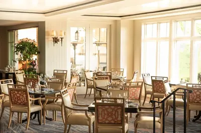 a dining room with tables and chairs and windows at Montage Laguna Beach in Laguna Beach
