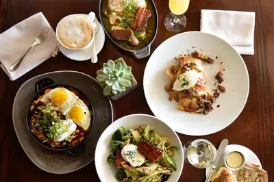 a wooden table with plates of food on it at Montage Laguna Beach in Laguna Beach