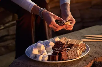 a person holding a piece of chocolate on a plate at Montage Laguna Beach in Laguna Beach