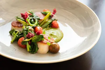 a plate of food with vegetables on a table at Montage Laguna Beach in Laguna Beach