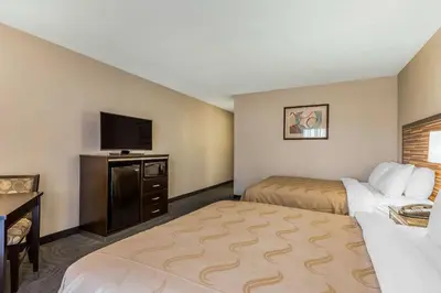 a hotel room with two beds and a flat screen tv at Quality Inn Fallbrook I-15 in Fallbrook
