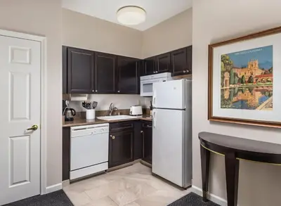 a kitchen with black cabinets and a white refrigerator at WorldMark San Diego - Balboa Park in San Diego
