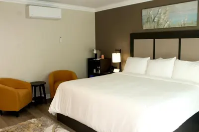 a bedroom with a large white bed and a chair at Econo Lodge Lake Elsinore Casino in Lake Elsinore