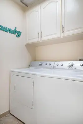a kitchen with white cabinets and a white dishwasher at Luxury Penthouse with Elevator - Sleeps 10+ - Family Friendly Sun / Surf / Sand in San Diego