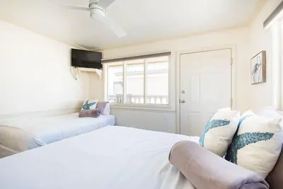 a white bedroom with two beds and a window at Luxury Penthouse with Elevator - Sleeps 10+ - Family Friendly Sun / Surf / Sand in San Diego