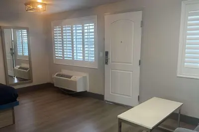 a living room with a white door and a window at Super 8 by Wyndham Oceanside Downtown in Oceanside