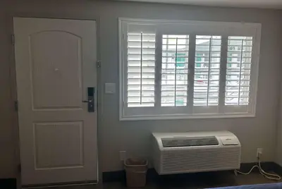 a room with a window and a heater next to a door at Super 8 by Wyndham Oceanside Downtown in Oceanside