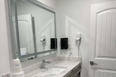 a bathroom with a sink and a large mirror at Super 8 by Wyndham Oceanside Downtown in Oceanside