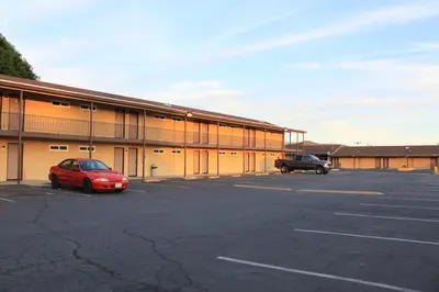 a building with a car parked in a parking lot at Menifee Inn in Menifee