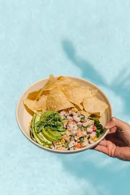 a person holding a plate with a salad and chips at Four Seasons Residence Club Aviara in Carlsbad