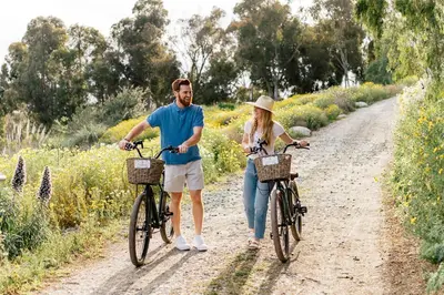 a man and woman walking their bikes down a dirt road at Four Seasons Residence Club Aviara in Carlsbad