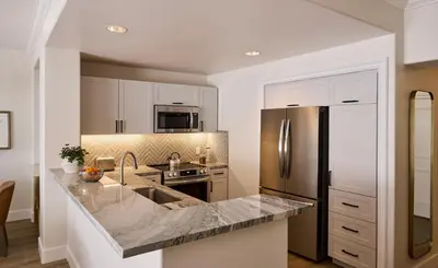a kitchen with white cabinets and a stainless steel refrigerator at Four Seasons Residence Club Aviara in Carlsbad