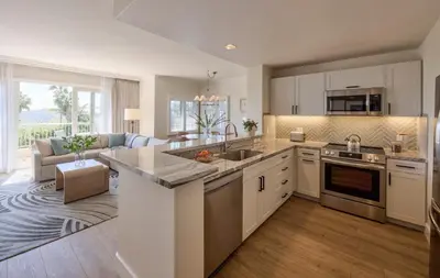 a kitchen with white cabinets and a living room at Four Seasons Residence Club Aviara in Carlsbad