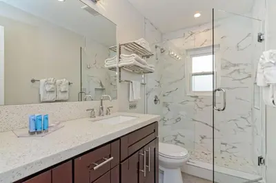 a white bathroom with a sink and a shower at Ocean Villas Beach Front in Carlsbad