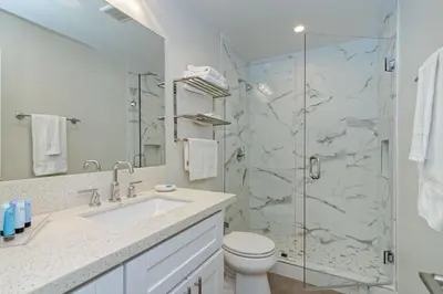 a bathroom with a shower and a toilet and a sink at Ocean Villas Beach Front in Carlsbad