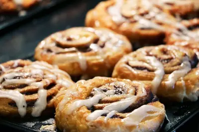 a bunch of donuts with icing on a tray at Holiday Inn Express & Suites - Murrieta by IHG in Murrieta