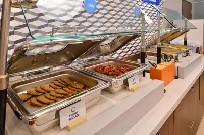 a buffet line with trays of food on a counter at Holiday Inn Express & Suites - Murrieta by IHG in Murrieta