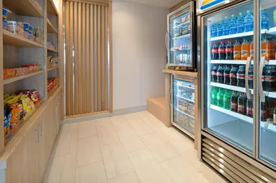 a store aisle with a refrigerator filled with drinks at Holiday Inn Express & Suites - Murrieta by IHG in Murrieta