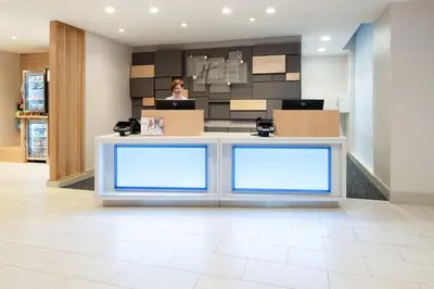a woman standing at a counter in a store at Holiday Inn Express & Suites - Murrieta by IHG in Murrieta