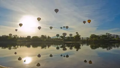 a group of hot air balloons flying over a lake at Holiday Inn Express & Suites - Murrieta by IHG in Murrieta