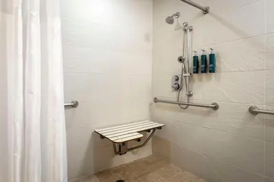 a bathroom with a shower with a bench in it at DoubleTree by Hilton San Diego Bayside in San Diego