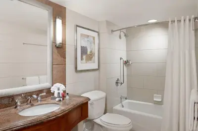 a bathroom with a toilet and a sink and a tub at San Diego Marriott Gaslamp Quarter in San Diego
