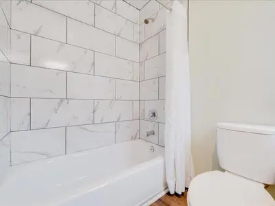 a white bathroom with a tub and a toilet at The Atwood Hotel San Diego - SeaWorld/Zoo in San Diego