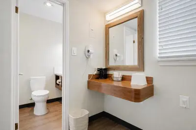 a bathroom with a mirror and a toilet at The Atwood Hotel San Diego - SeaWorld/Zoo in San Diego