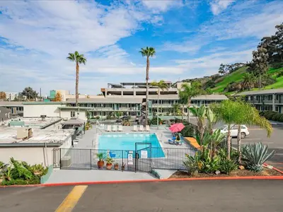 a resort with a swimming pool and palm trees at The Atwood Hotel San Diego - SeaWorld/Zoo in San Diego