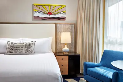a hotel room with a bed and a blue chair at The Bristol Hotel San Diego in San Diego