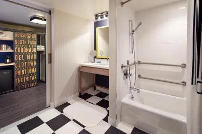 a bathroom with a shower and a tub and a sink at The Bristol Hotel San Diego in San Diego