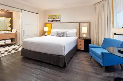 a hotel room with a bed and a blue chair at The Bristol Hotel San Diego in San Diego
