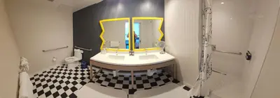 a bathroom with a sink with a mirror and a checkered floor at The Bristol Hotel San Diego in San Diego