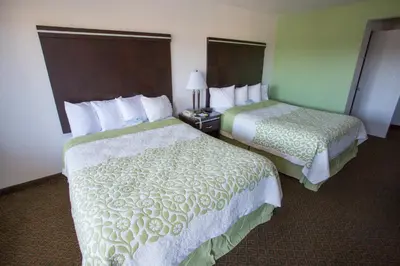 a hotel room with two beds and a lamp at Days Inn by Wyndham Oceanside in Oceanside