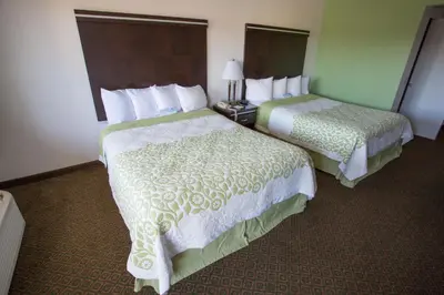 two beds sitting in a hotel room with at Days Inn by Wyndham Oceanside in Oceanside