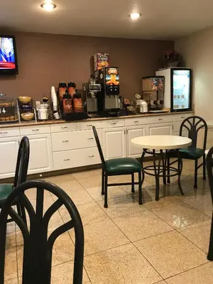 a restaurant with a table and chairs and a counter at Days Inn by Wyndham Oceanside in Oceanside