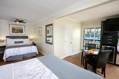 a bedroom with a bed and a desk and a table at Ocean Beach Hotel in San Diego