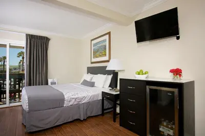 a hotel room with a bed and a flat screen tv at Ocean Beach Hotel in San Diego