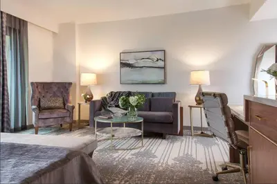 a hotel room with a couch and a chair at Legacy Resort Hotel & Spa in San Diego