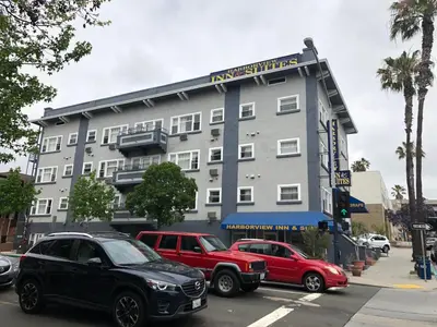 a large building with cars parked in front of it at Harborview Inn & Suites-Convention Center-Airport-Gaslamp-Seaworld-Zoo-Balboa Park in San Diego