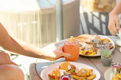 a table with a plate of food and a candle at Andaz San Diego, By Hyatt in San Diego