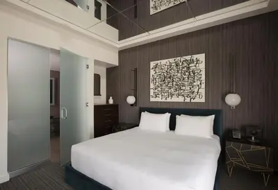 a bedroom with a large white bed and wooden walls at Andaz San Diego, By Hyatt in San Diego