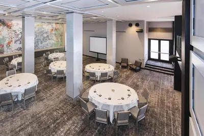 a conference room with tables and chairs and a projection screen at Andaz San Diego, By Hyatt in San Diego
