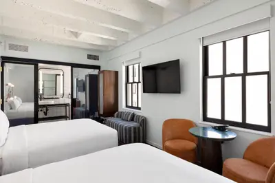 a hotel room with two beds and a tv at The Guild Hotel, San Diego Downtown, a Tribute Portfolio Hotel in San Diego