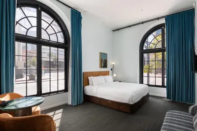 a bedroom with a bed and two large windows at The Guild Hotel, San Diego Downtown, a Tribute Portfolio Hotel in San Diego