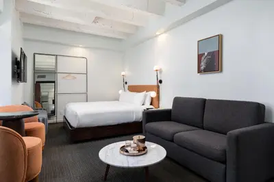 a hotel room with a bed and a couch and a table at The Guild Hotel, San Diego Downtown, a Tribute Portfolio Hotel in San Diego