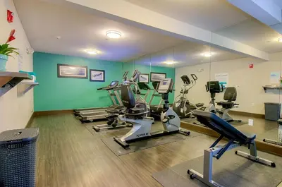 a gym with several treadmills and exercise bikes in a room at Holiday Inn Express Hotel & Suites Carlsbad Beach by IHG in Carlsbad
