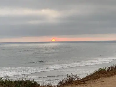 a sun setting over the ocean with the beach at Holiday Inn Express Hotel & Suites Carlsbad Beach by IHG in Carlsbad